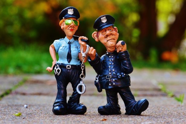 Agentes policiais uniformizados ao lado de uma viatura, em uma imagem ilustrativa sobre segurança pública.