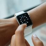 Relógio inteligente com tela digital no pulso, representando o uso de tecnologia vestível para monitoramento e segurança.