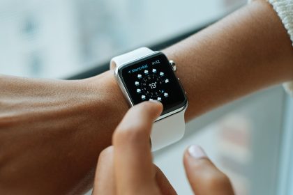 Relógio inteligente com tela digital no pulso, representando o uso de tecnologia vestível para monitoramento e segurança.